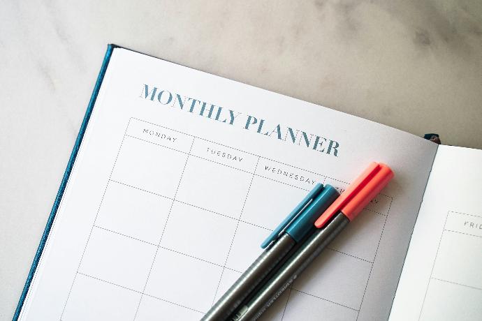 a planner with two pens sitting on top of it